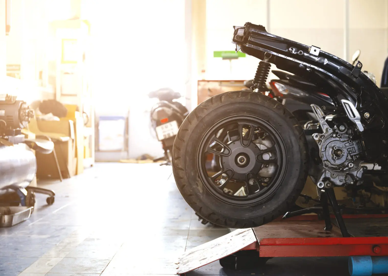 Motorcycle repair in a sunlit workshop.
