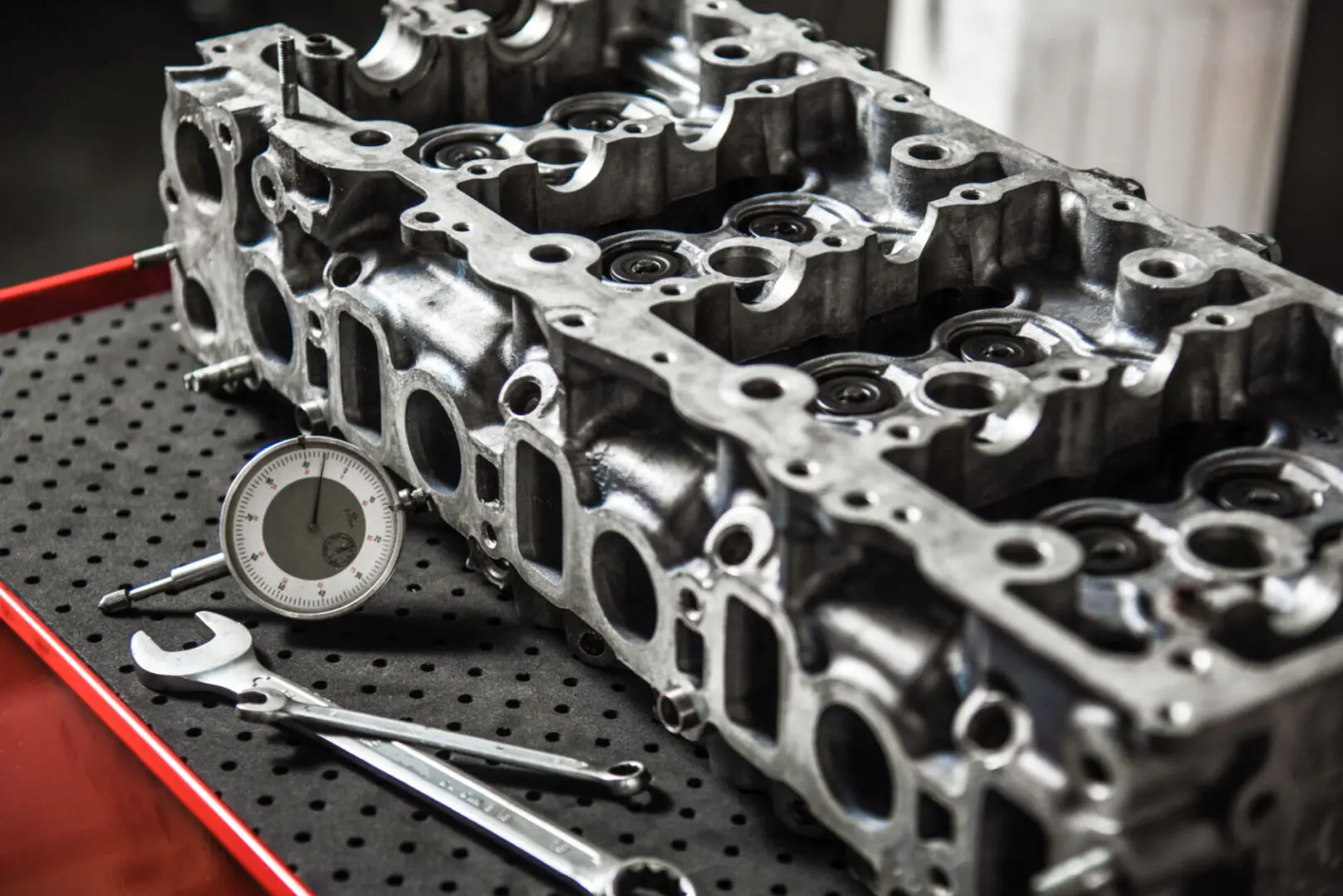 Engine cylinder head with tools on table.